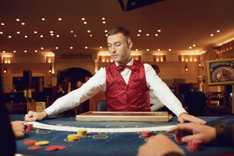 Croupier tiene le carte da poker nelle sue mani a un tavolo