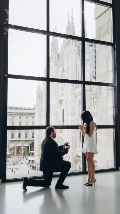 Proposta di matrimonio davanti alla grande vetrata del Museo del Novecento affacciata sul Duomo di Milano